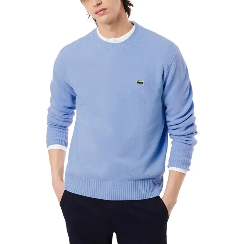 Pull Lacoste bleu clair pour homme, en laine, col rond, poignets côtelés et logo crocodile vert sur la poitrine gauche.