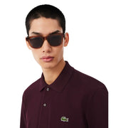 Lunettes de soleil Lacoste à monture écaille marron et verres foncés, portées avec un t-shirt Lacoste homme en coton violet.