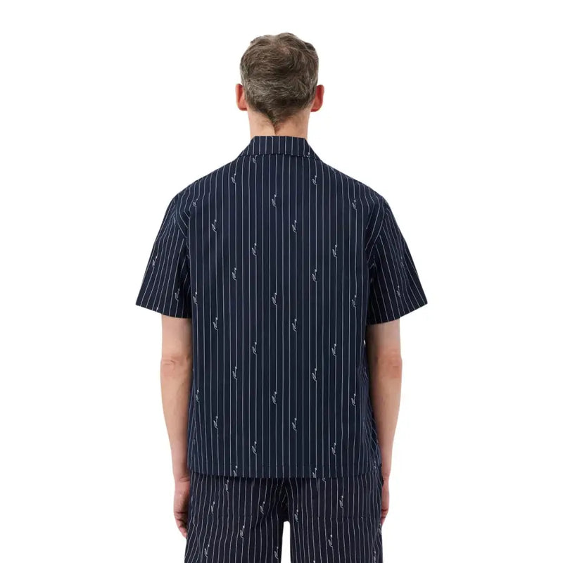Chemise Lacoste homme bleu marine à manches courtes, ornée de fines rayures verticales blanches et de motifs d'ancre brodés.