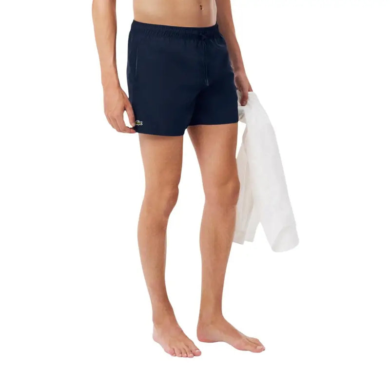 Navy blue Lacoste men swim trunks with small green crocodile logo on left leg designed for swimwear use