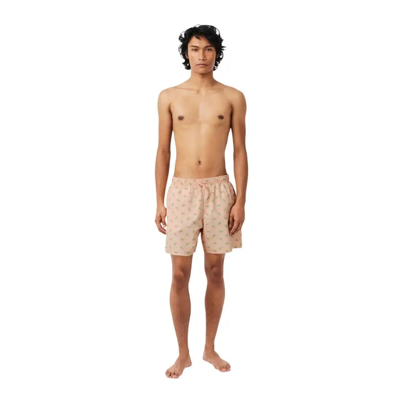 Light pink Lacoste men swimwear trunks featuring a subtle green and yellow pineapple pattern