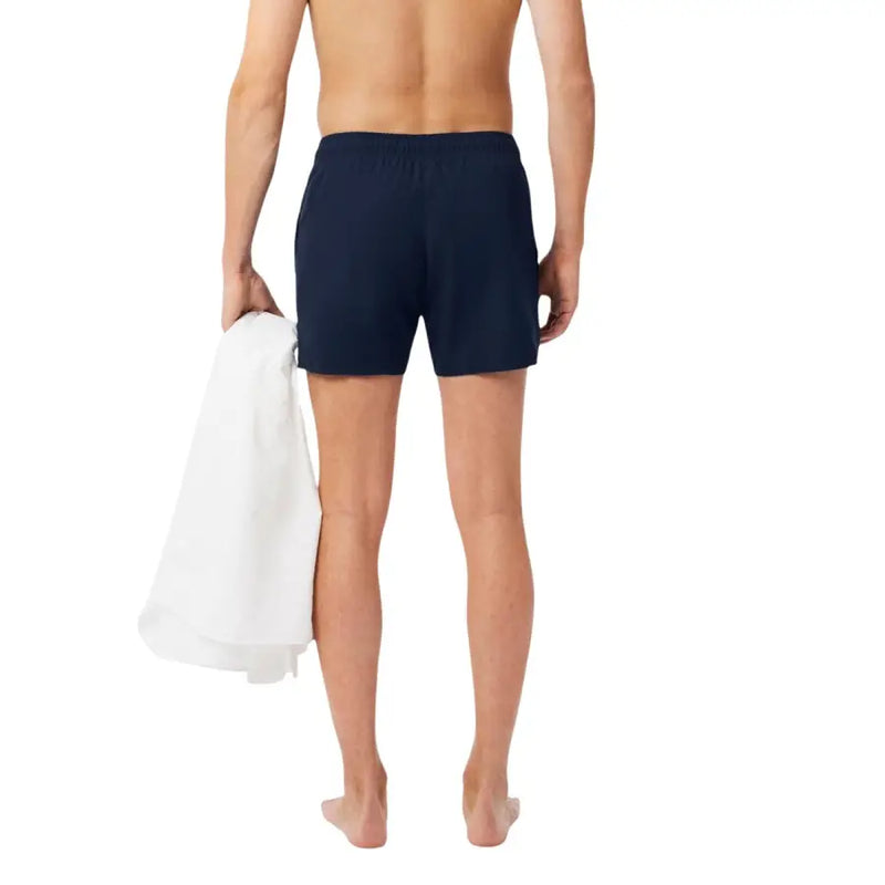 Navy blue Lacoste men swimwear featuring elastic waistband swim trunks ideal for beach or pool use