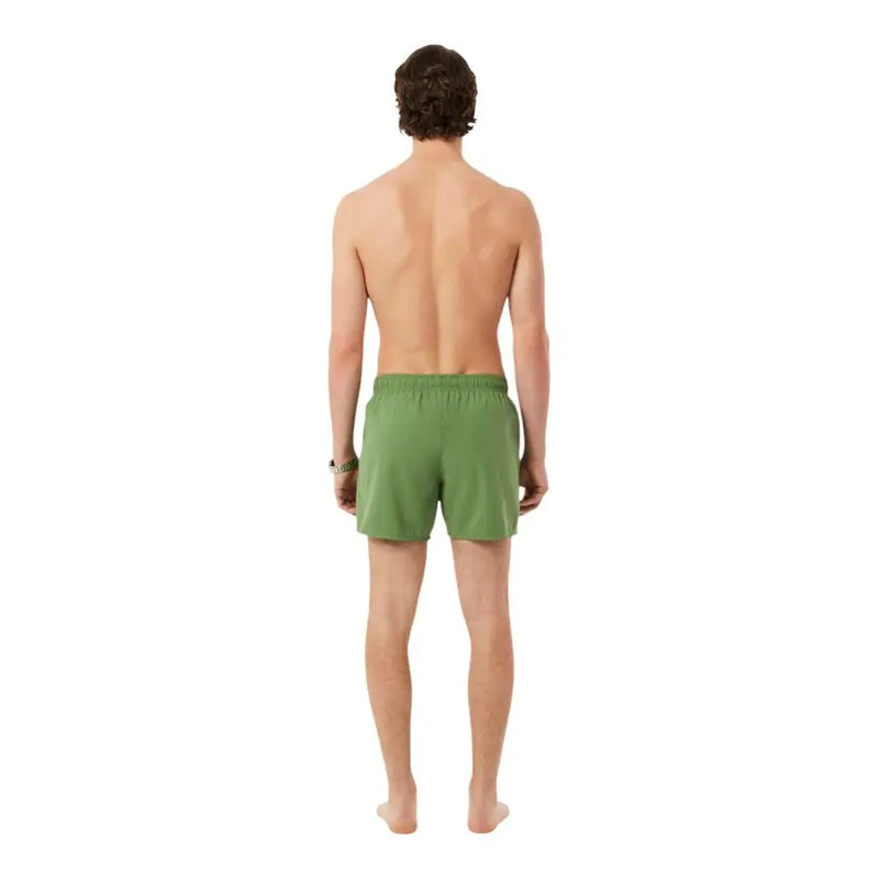Un short de bain Lacoste pour homme, vert, en polyester, avec taille élastique et poches.