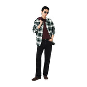 Un homme portant un t-shirt Lacoste bordeaux en coton, associé à une chemise en flanelle à carreaux noirs et blancs et un jean foncé.
