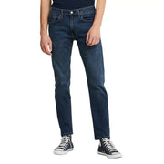 Dark blue levi’s 501 straight leg jeans with white stitching and black converse sneakers.