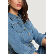 Light blue belted jumpsuit with pockets and three quarter sleeves paired with a blue denim jacket with gold buttons and collar