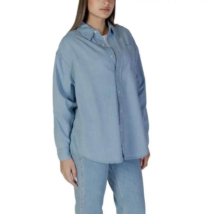Light blue long sleeve collared button-up shirt by Calvin Klein Jeans for women