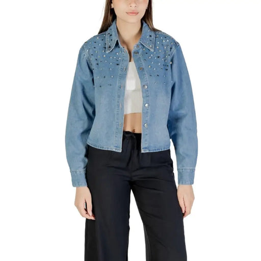 Light blue embellished denim jacket with silver studs displayed on a mannequin