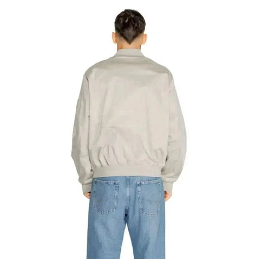 Light gray bomber jacket worn by a person facing away from the camera by Calvin Klein