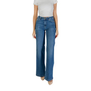 Woman wearing white short-sleeve top and flared blue Liu Jo ankle-length jeans