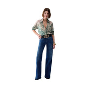 Une femme porte un jean Liu Jo bleu marine en coton stretch, coupe large, et une ceinture noire à boucle dorée ornée du logo.