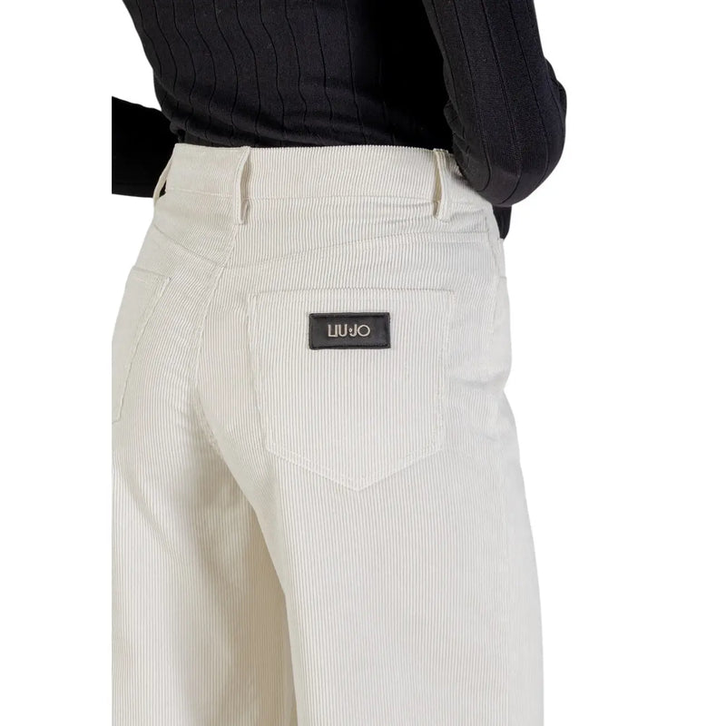 Pantalon en velours côtelé couleur crème avec une texture côtelée verticale discrète et un écusson de la marque Liu Jo en cuir noir
