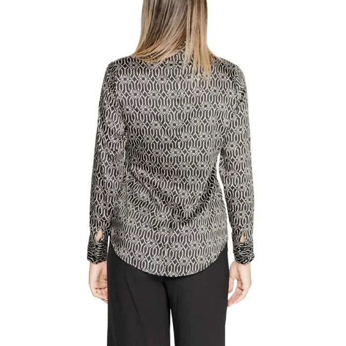 Long-sleeved black and white patterned blouse with curved hemline and lapel collar
