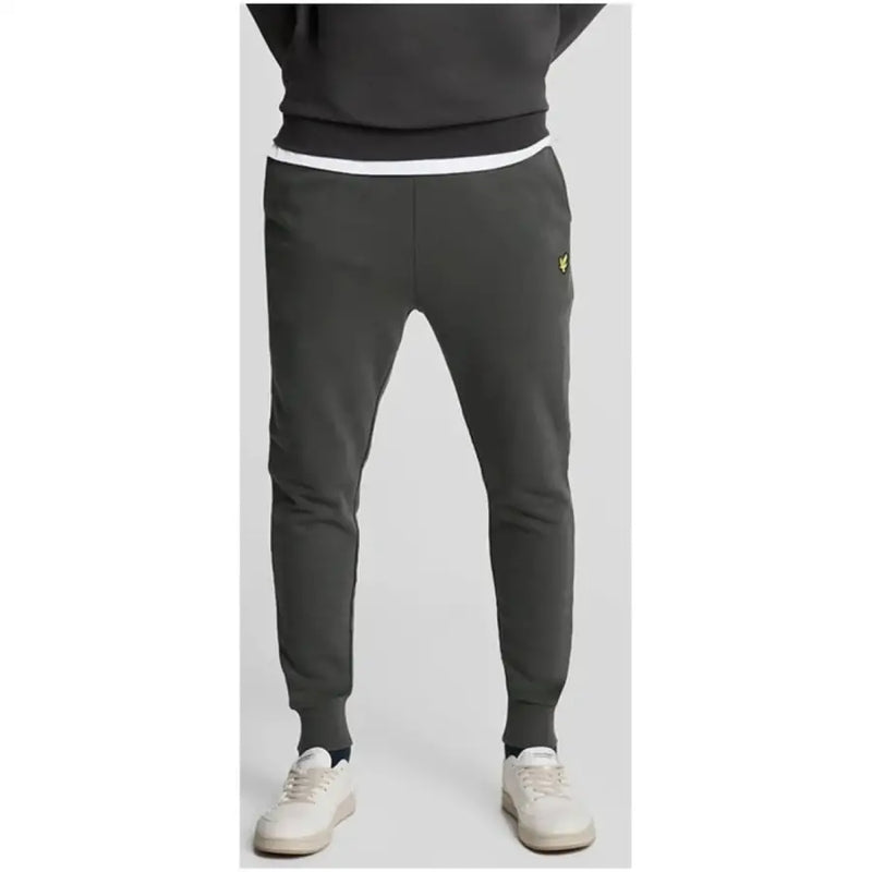 Lyle & Scott Pantalon gris en coton pour homme, avec poches avant, ceinture blanche et logo jaune sur la cuisse.