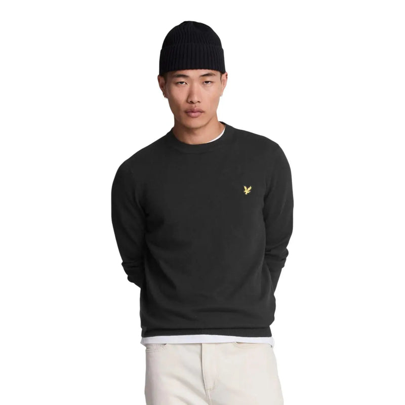 Lyle & Scott Pull en laine mérinos noire pour homme, orné d'un logo oiseau doré sur la poitrine gauche (vue de face).