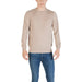 Man wearing a beige long-sleeved sweater and blue jeans suitable for casual wear