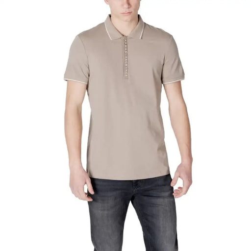 Man wearing beige polo shirt and dark jeans, showcasing Armani Exchange Men’s Blue Cotton Polo Shirt