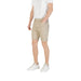 Man wearing beige chino shorts and white sneakers displaying a casual summer outfit