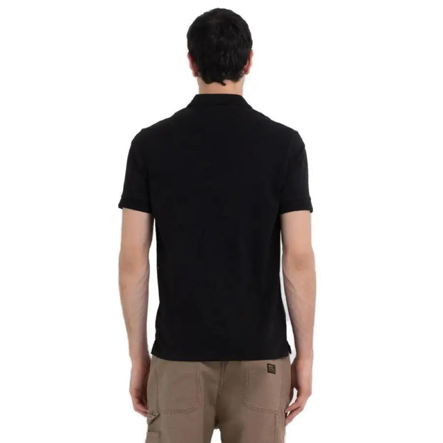 
                      
                        Man in Replay Polo showcasing urban style clothing in black shirt and khaki pants
                      
                    