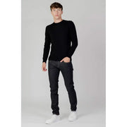 Man wearing a black sweater and dark wash denim jeans for the product display