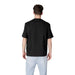 Man wearing a black t-shirt and light blue pants showcasing Armani Exchange Men Black Cotton T-Shirt