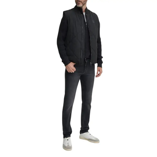 Man wearing black vest and jeans modeling the Black Ribbed Knit Sweater for Men