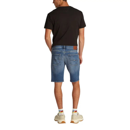Man wearing blue denim shorts and a black T shirt displayed in product listing