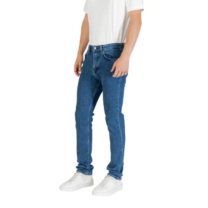 Man wearing Blue Denim Jeans for Men with white sneakers, showcasing casual style