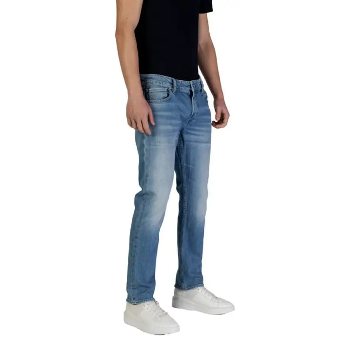 Man in blue jeans and white sneakers from Guess Men Blue Jeans Spring Summer Collection