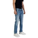 Man in blue jeans and white sneakers from Guess Men Blue Jeans Spring Summer Collection