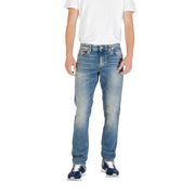 Man wearing light blue jeans and blue sneakers showcasing men’s fashion