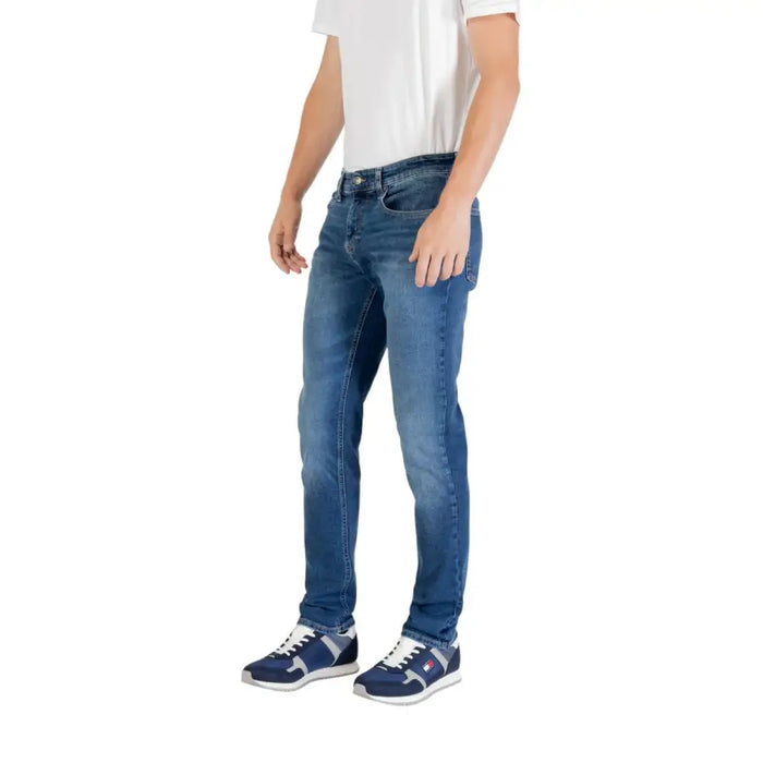 Man wearing blue denim jeans and sneakers showcasing the Men’s Blue Denim Jeans product