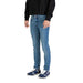 Man wearing light blue denim jeans and sneakers standing confidently