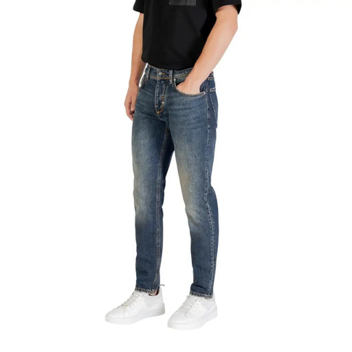 Man dressed in Blue Jeans and White Sneakers, showcasing men’s casual fashion