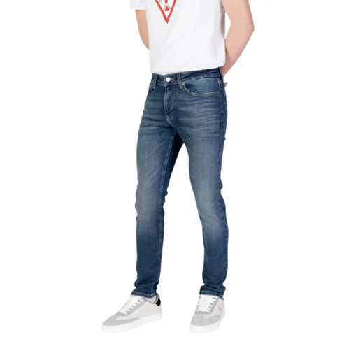 Man in Tommy Hilfiger Men’s Blue Jeans with Front and Back Pockets and White Sneakers