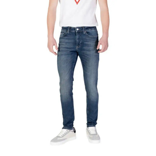 Man wearing Tommy Hilfiger Men’s Blue Jeans with front and back pockets and white sneakers