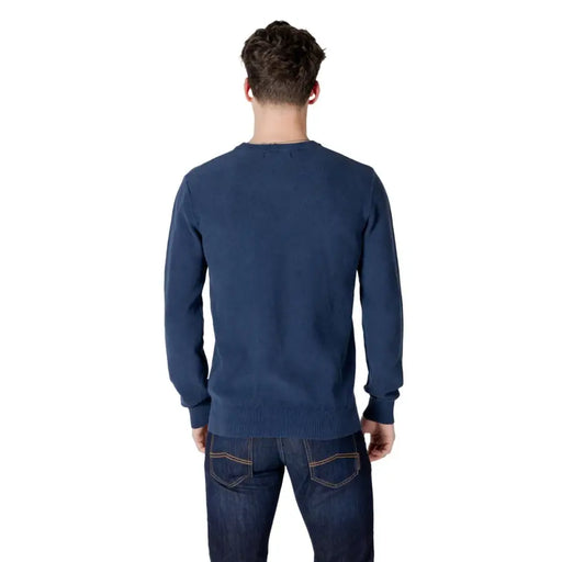 Man wearing a blue long-sleeve shirt and jeans in a Mens Blue Sweater and Jeans Ensemble