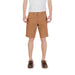 Man wearing brown shorts and boat shoes in a stylish ensemble showcasing men’s casual fashion