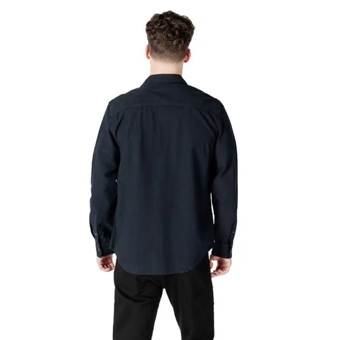 Man wearing a dark button-down shirt, suitable for formal and casual occasions