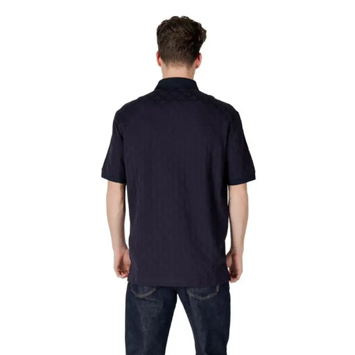 Man wearing Armani Exchange Blue Polo Shirt with dark jeans in casual setting