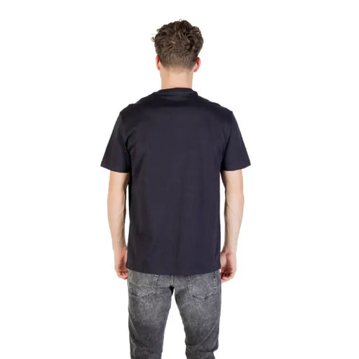 Man wearing navy blue short sleeved T shirt and gray jeans showcasing casual style