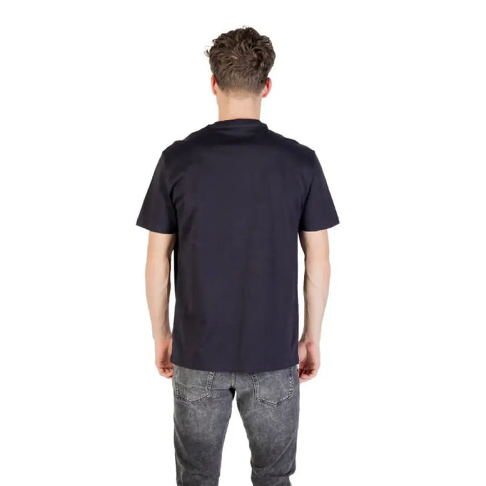 Man wearing navy blue short sleeved T shirt and gray jeans showcasing casual style