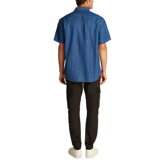 Man wearing a blue denim short sleeved shirt and cargo pants for Men product display