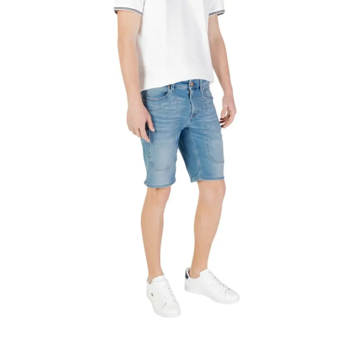 Man wearing denim shorts and white sneakers showcasing Men’s Denim Shorts and White Sneakers