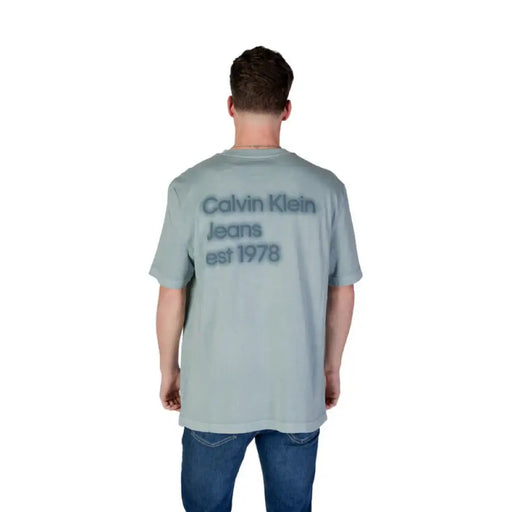 Man modeling a gray Calvin Klein t-shirt from the Calvin Klein Jeans collection