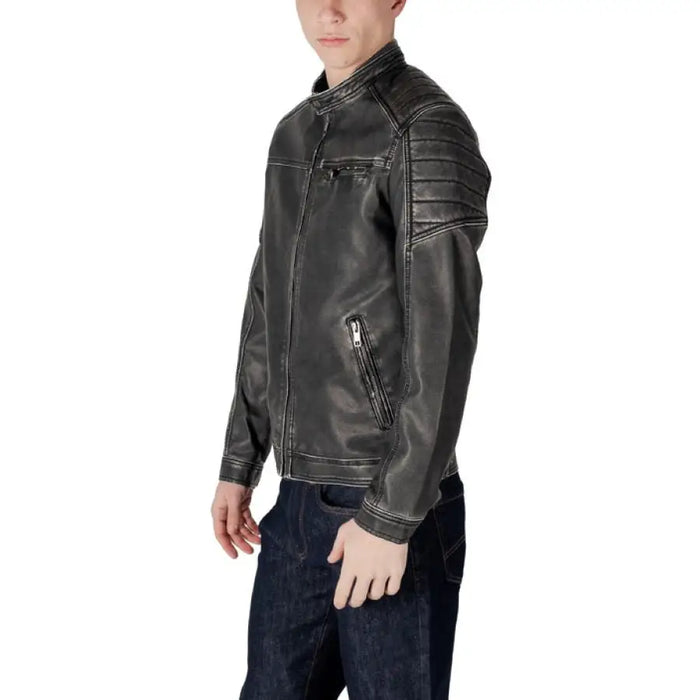 Man wearing a gray leather jacket paired with jeans in stylish urban setting