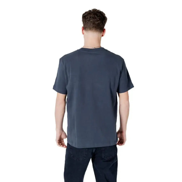 Man wearing a gray T-shirt and dark jeans from Mens Blue and Gray T-Shirts and Dark Jeans collection