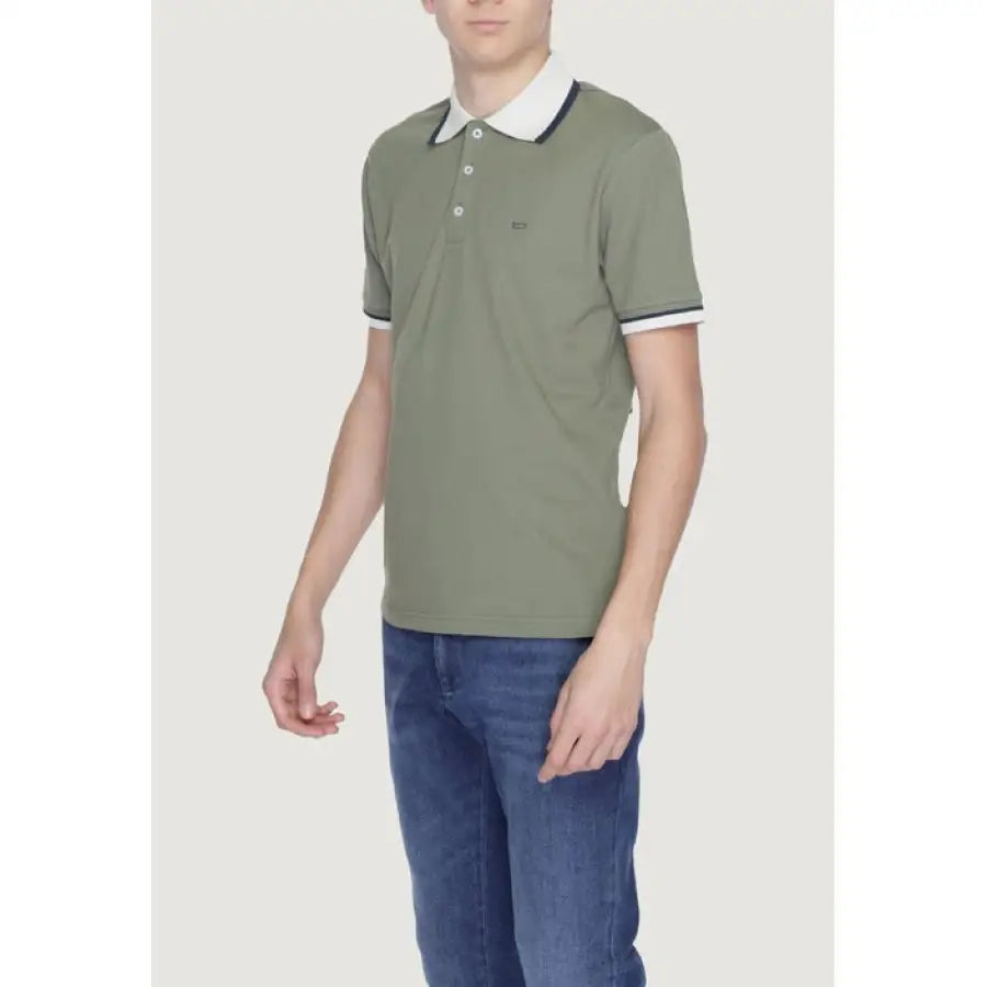 
                      
                        Man in Gas Men Polo, urban style clothing with green shirt and blue jeans
                      
                    