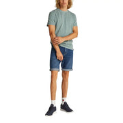 Man wearing a green T-shirt and denim shorts in a product display