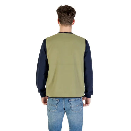 Man wearing a green vest and blue jeans, showcasing Olive Green Vest for Men